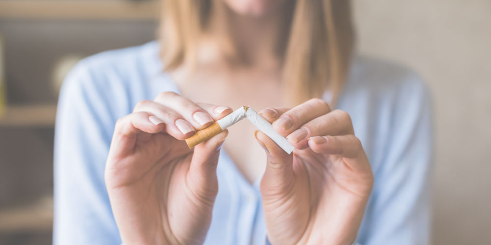 Persona rompiendo un cigarrillo